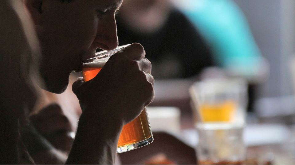 A man drinks a pint of beer.