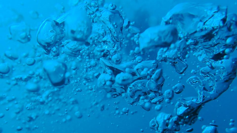 Bubbles form in blue water.