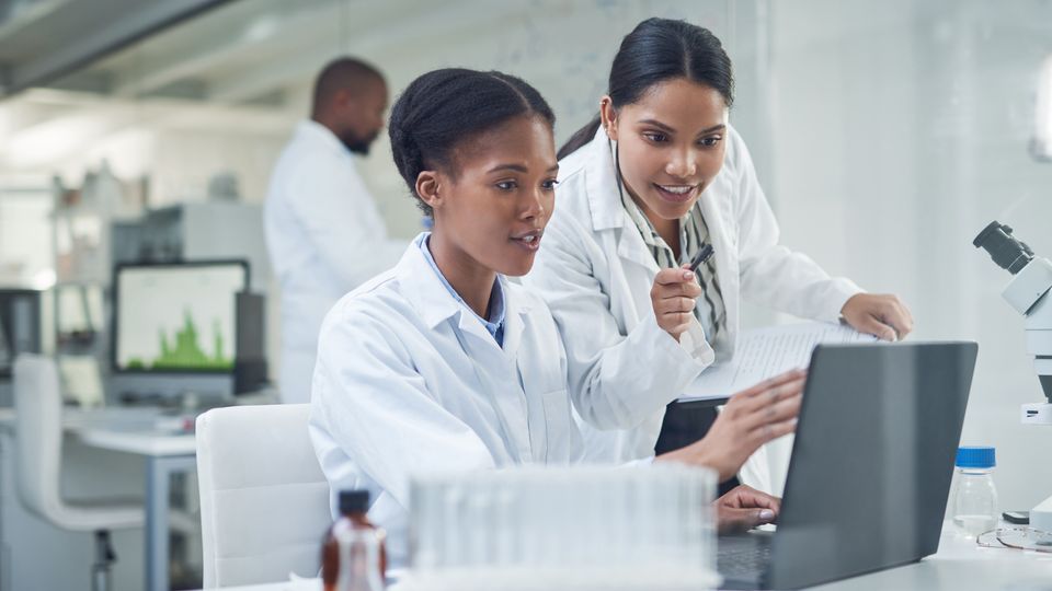 Two scientists looking at a laptop screen.