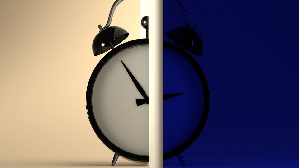 An alarm clock split into daytime and nightime.