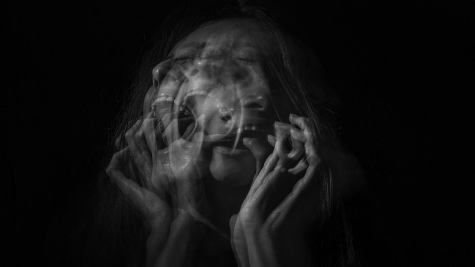 A blurred photo of a woman screaming in pain.