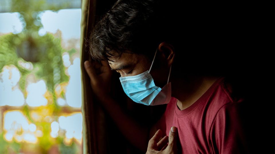 A man wearing a mask has a side effect after suffering from COVID-19 during the pandemic