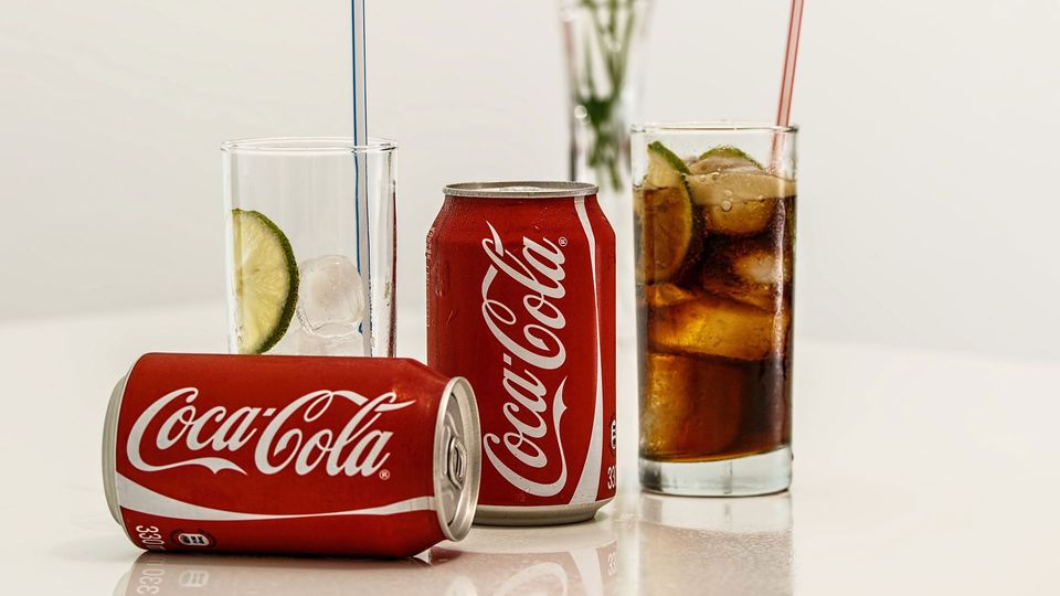 Coca-cola cans poured into glasses