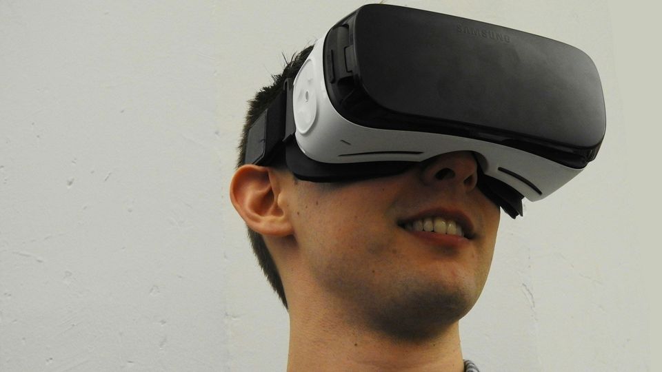 A young man wears a VR headset.