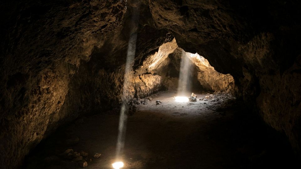 Beams of light break through into a cave.