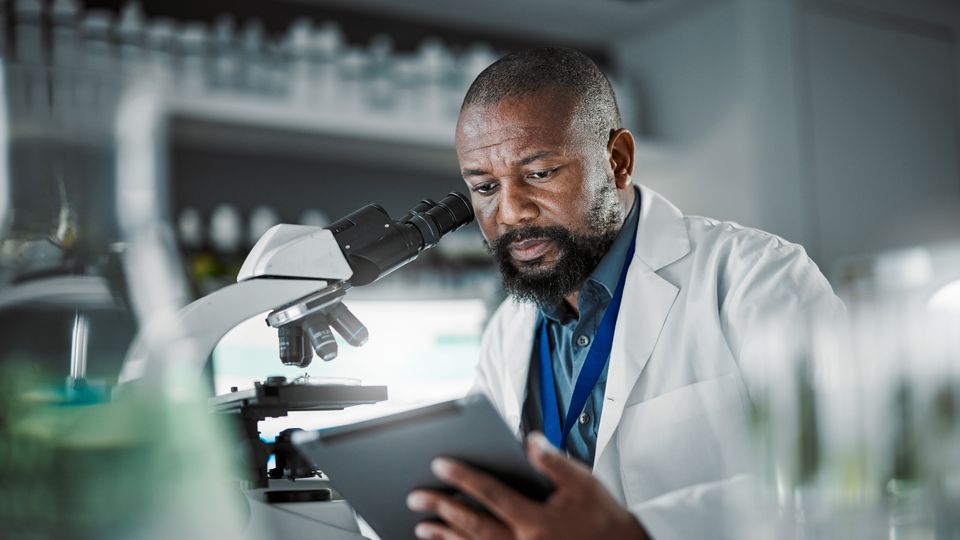 A scientist looking at a tablet screen.