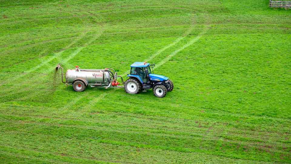 A tractor spreading fertilizer on a field.
