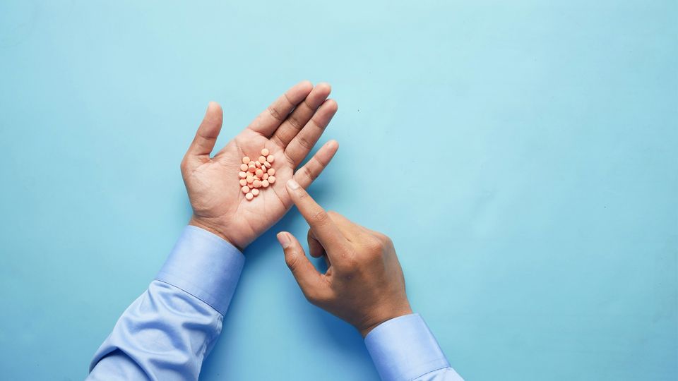 A man pointing to drugs in his hand.