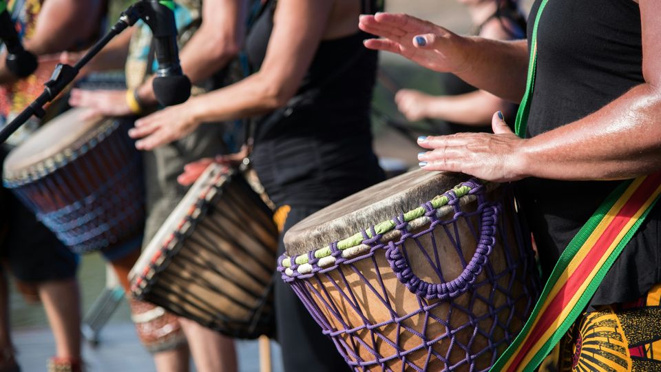 A group of people playing hand drums.