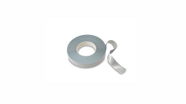 Roll of lateral flow striping tape with a partially unrolled end on a white background.