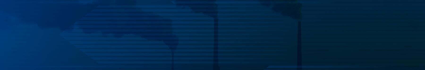 Industrial smokestacks emitting thick plumes of smoke into a hazy sky at sunset, highlighting air pollution 