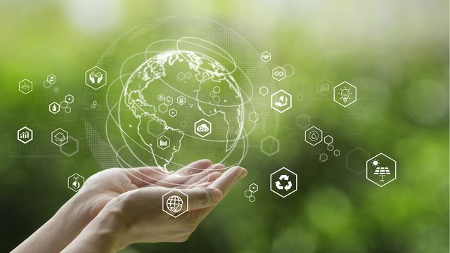 Hands holding a digital Earth with eco icons, symbolizing lab sustainability and green practices. 