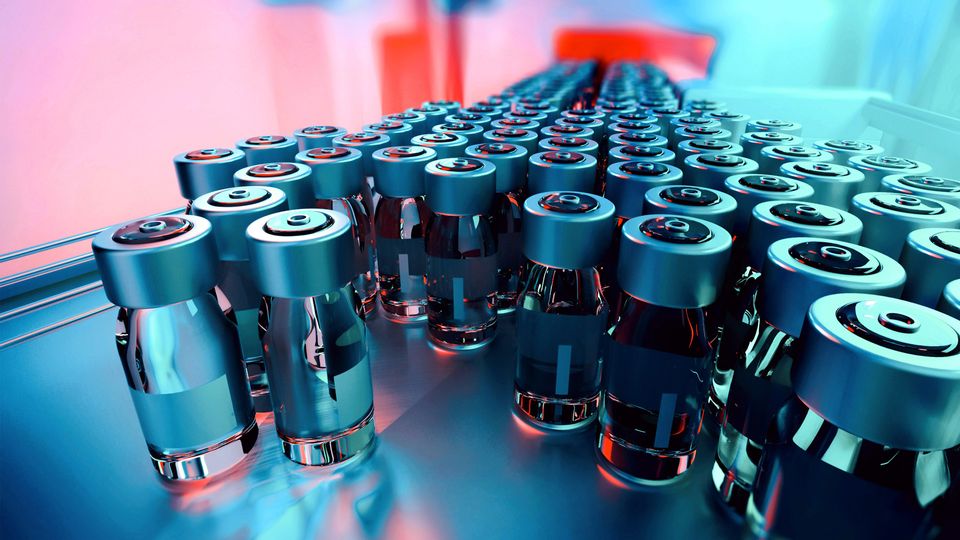 Rows of pharmaceutical vials on a production line, relevant to host cell protein analysis in biologics.