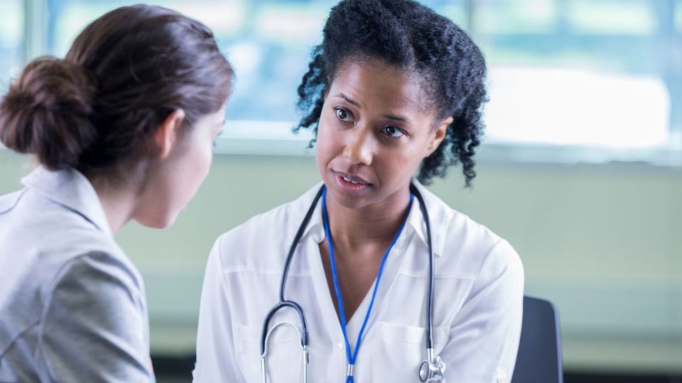 Doctor providing supportive HPV consultation to a concerned patient in a clinical setting.