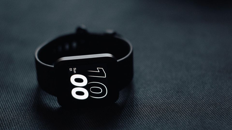 Back smartwatch lying on side with the time showing.