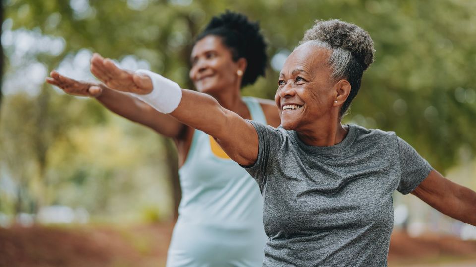 Older women practicing outdoor exercise, staying active and healthy in a park.