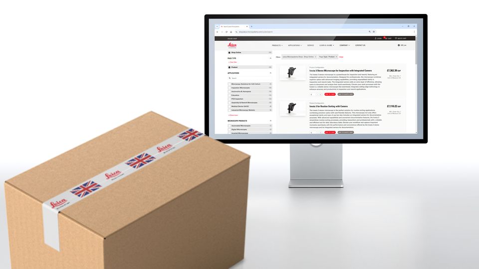 A cardboard box with a UK-styled shipping label alongside a computer screen displaying an online shopping platform.