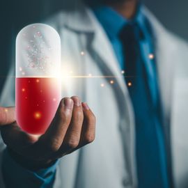 A researcher holding up a hologram of a molecule in a pill, representing AI-driven anti-infective discovery. 