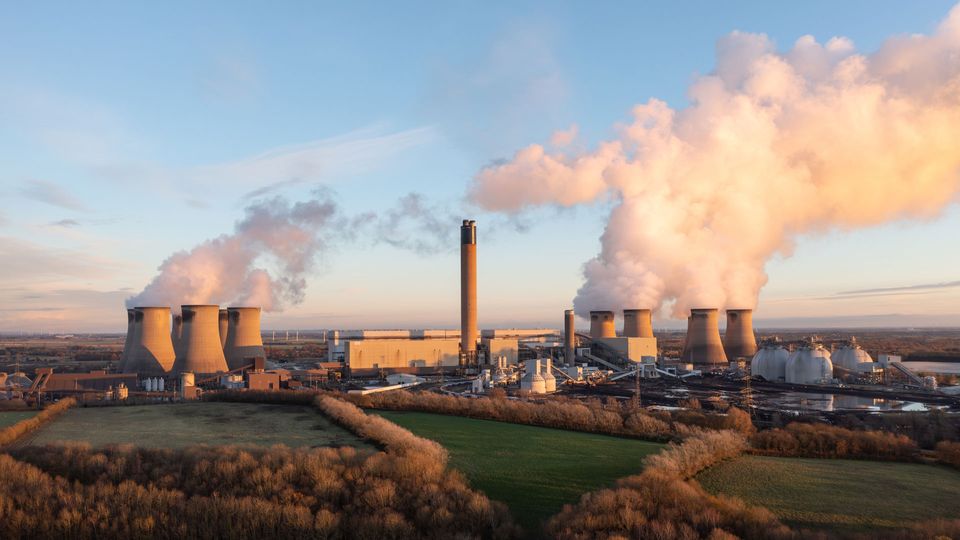 Photograph of power station with smoke coming from towers.