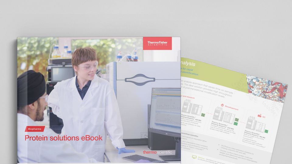 Scientists in a lab analyzing protein data on a computer for biotherapeutic research using Thermo Fisher Scientific equipment.