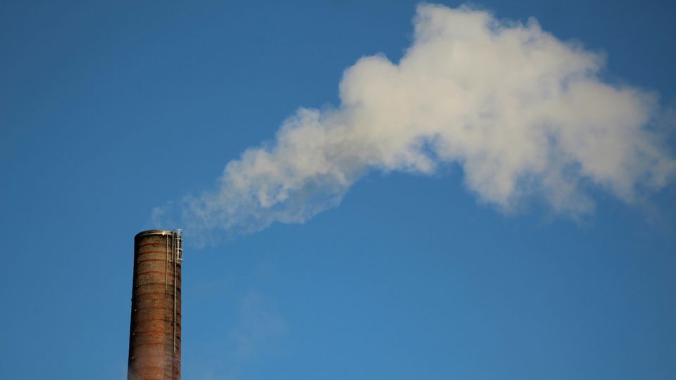 An industrial chimney releasing white vapor into the air