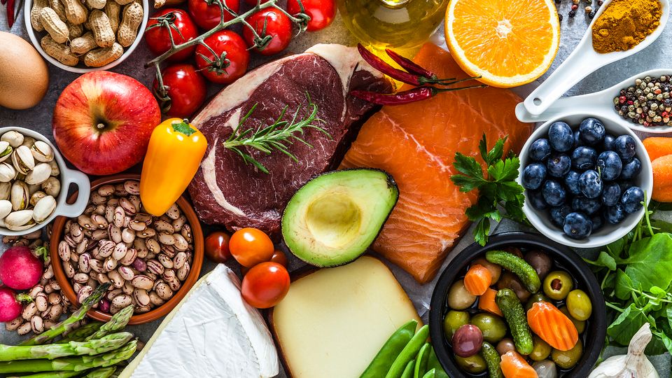 Assortment of fresh and colorful foods including fruits, vegetables, meat, fish and dairy.
