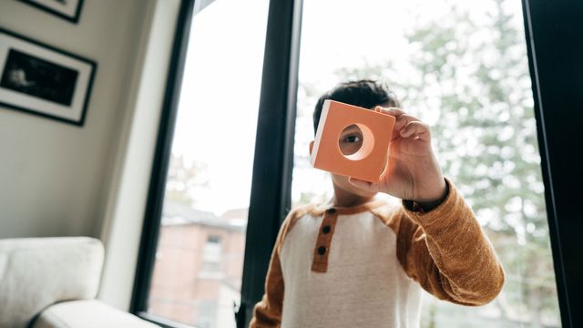 Child with toy brick that has a circle in the middle. 