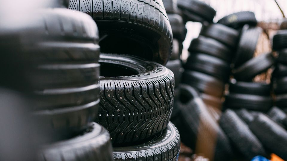 Stacks of black tires in a workshop.