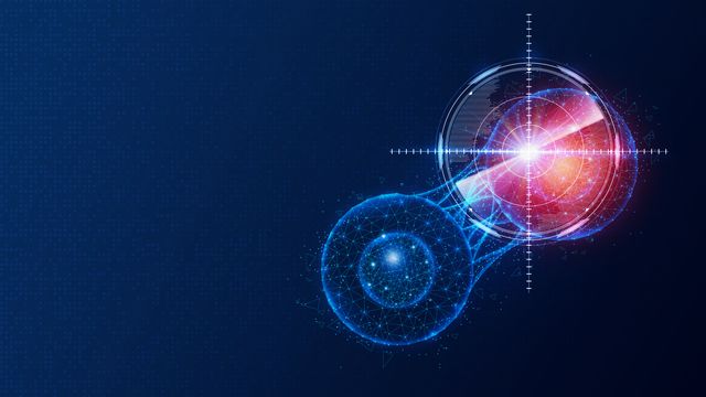 A graphic of two blue balls dividing, one with a red glow in white crosshairs.