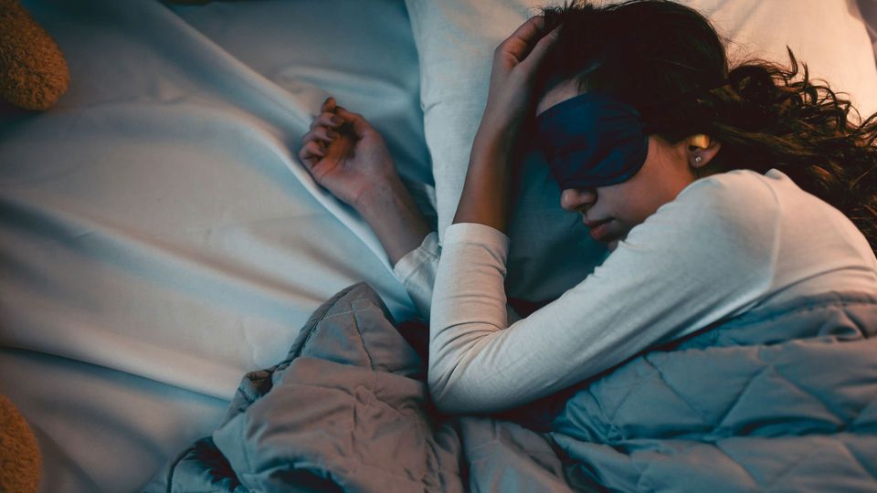Woman sleeping with sleep mask and earplugs in.