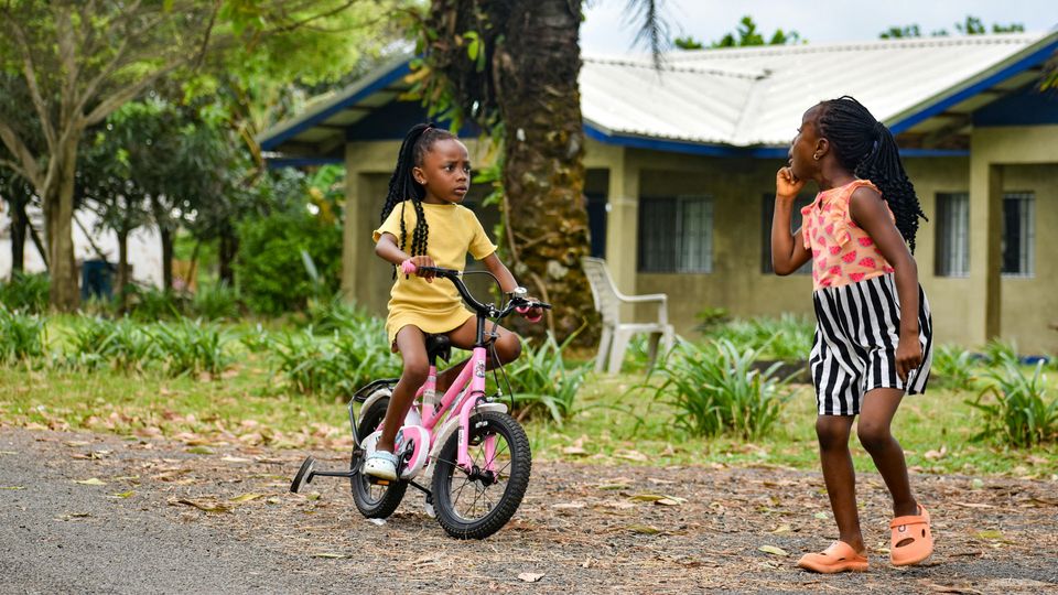 African children playing on a bicycle.