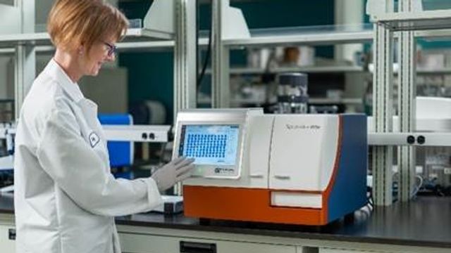 Scientist operating a SpectraMax® iD5e Multi-Mode Microplate Reader in a laboratory setting.