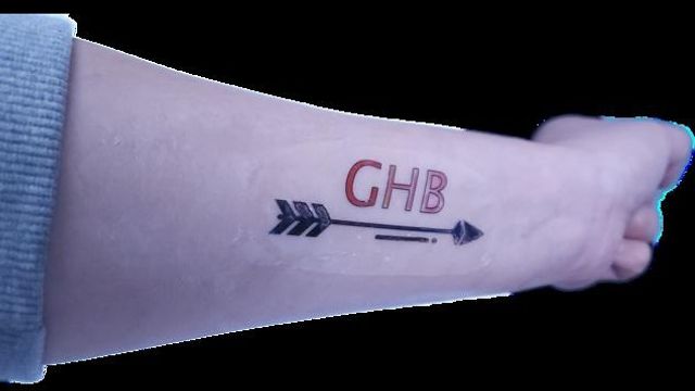 GHB detection sticker on forearm with arrow design, used for drug exposure monitoring. 