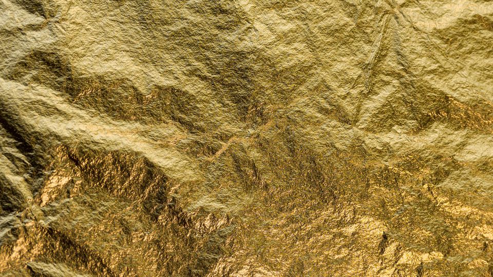 A close-up photograph of a sheet of gold foil.