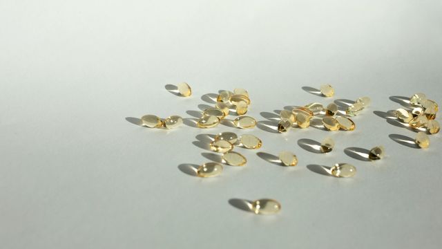 Many yellow, transparent health supplement capsules.