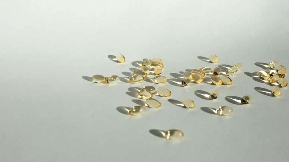 Many yellow, transparent health supplement capsules.