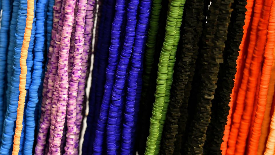 Rows of small polymer beads on strings, all different colors.