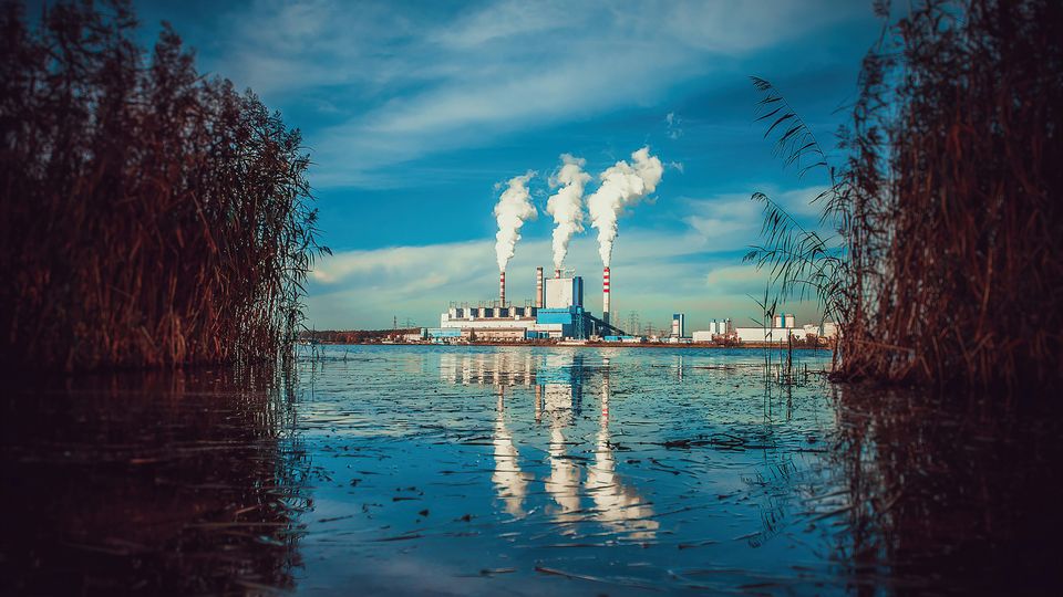 An industrial factory, as seen from across a body of water.