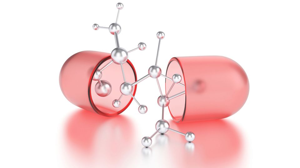 A red drug pill in half with a model of a molecule in the center.