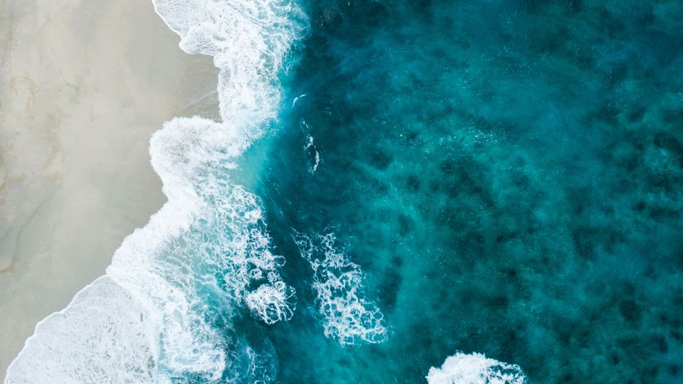 Surf lapping on sand, shot from above.