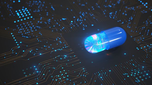 A blue drug pill on top of a black switchboard, representing AI-driven drug discovery. 