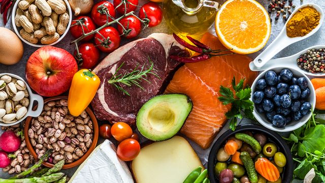 Assortment of fresh, less processed foods including fruits, vegetables, fish, meat, nuts and legumes. 