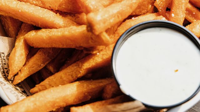Chips/French fries, salted in a bowl with newspaper