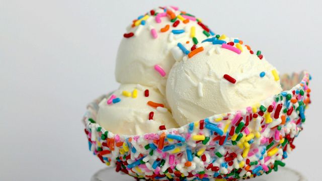 Three pale ice cream scoops in a 'bowl' of hundreds and thousands 