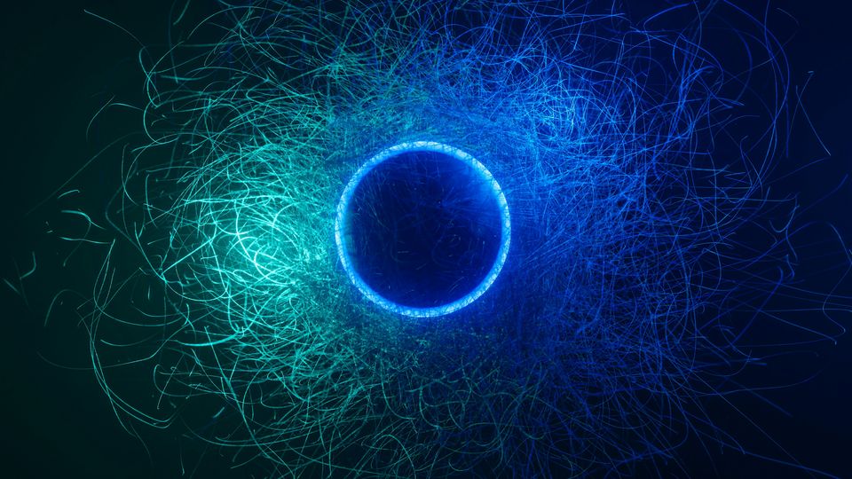 A glowing, dark sphere, surrounded by blue and green light trails.
