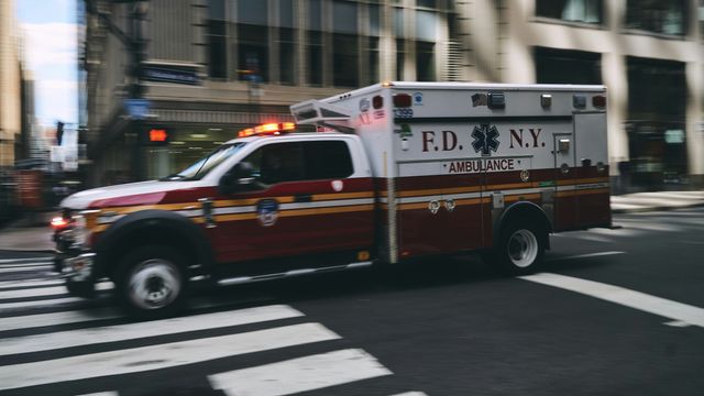 A US ambulance driving down a street at speed.  