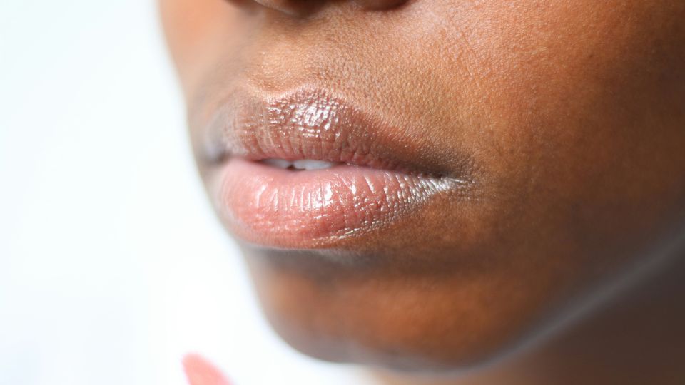 A close-up photograph of a Black woman's mouth and chin.