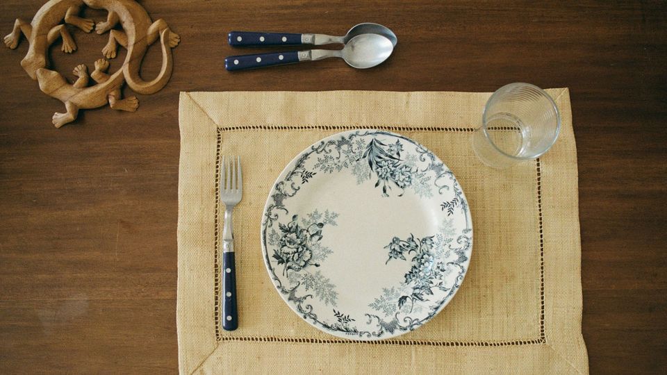 A place setting at a table, with an empty plate symbolizing fasting.