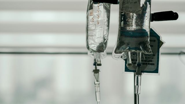 IV drip bags in front of a hospital window. 