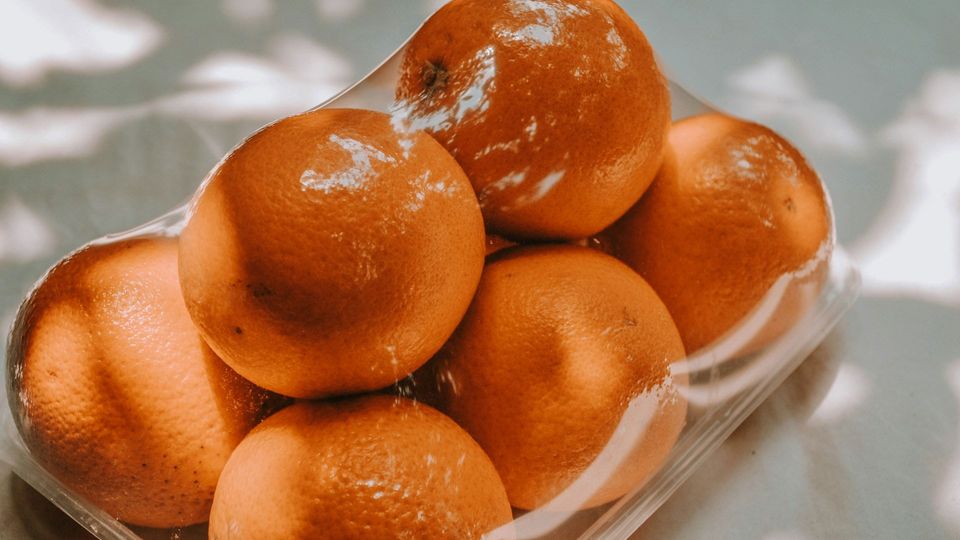 Oranges wrapped in a clear plastic.